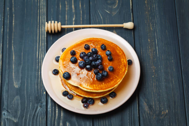 istock Pancakes with honey and blueberries on wooden table 892278258
