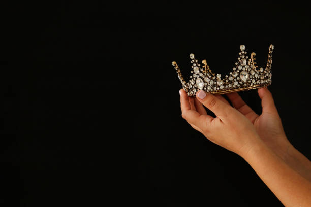 istock Woman's hand holding a crown for show victory or winning first place. 892281332