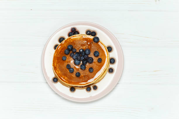 istock pancakes with honey and blueberries isolated on white background. 892281488