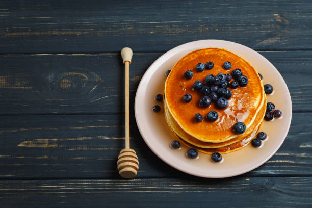 istock Pancakes with honey and blueberries on wooden table 892282276