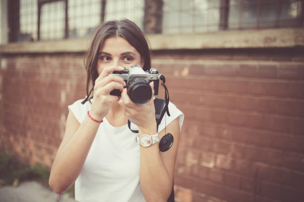 istock Young woman with vintage camera taking photos 892285734