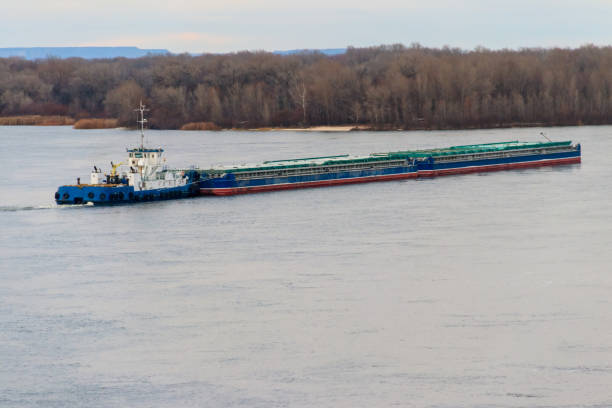 istock Tugboat pushing a heavy long barge on the river Dnieper 892289130