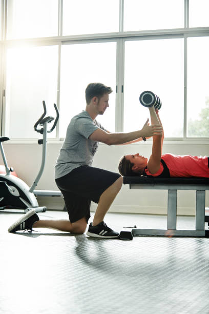 soutien constant dans cette salle de sport - weight bench flash photos et images de collection