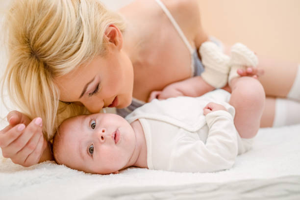 istock Mother and baby on a white bed 892300470