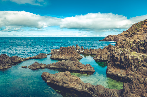 lava rocks natural volcanic pools in porto moniz, madeira island, portugal.