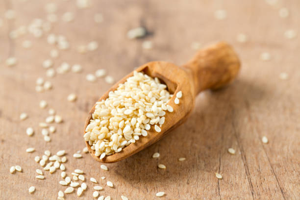 semillas de sésamo en una cuchara de madera - sesame seed spoon scoop fotografías e imágenes de stock