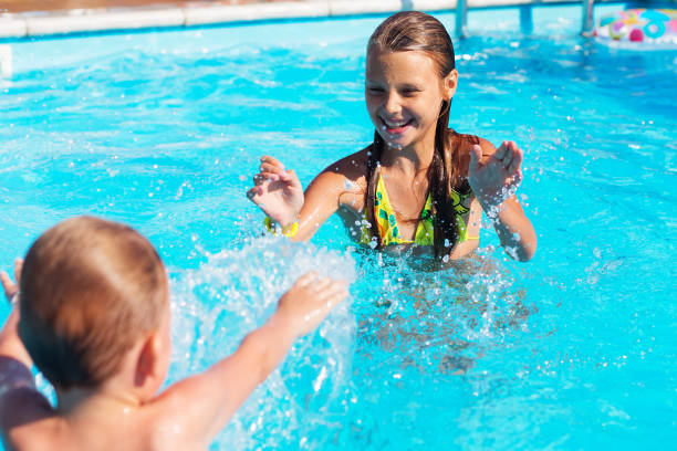 istock Little children playing and having fun in swimming pool 892312990