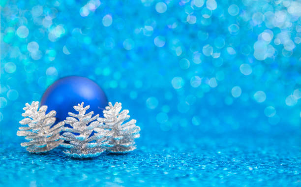 istock Blue christmas ornament and silver pinecones on blue 892323340