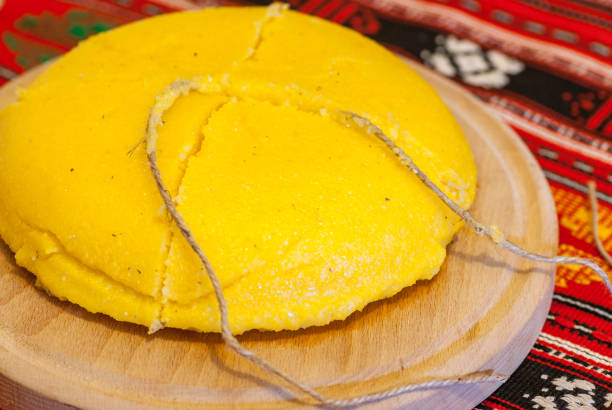 romanian traditional dish polenta mamaliga on wooden plate sliced with a string romanian traditional dish polenta mamaliga on wooden plate sliced with a string mamaliga stock pictures, royalty-free photos & images