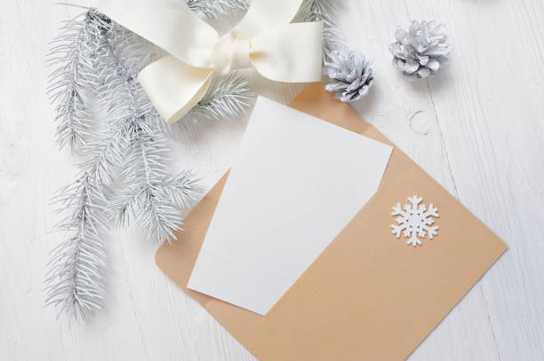 istock Mockup Christmas greeting card letter in envelope with white tree and cone, flatlay on a wooden background, with place for your text 892357176
