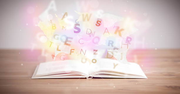 istock Open book with glowing letters on concrete background 892357518