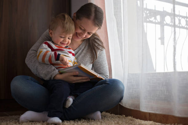 istock Mom reading a book to a baby boy 892362666