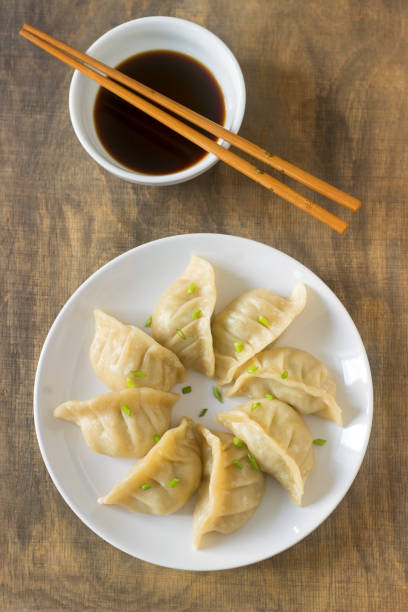 istock Eight boiled or fried jiaozi or gedza served with soy sauce. 892362692
