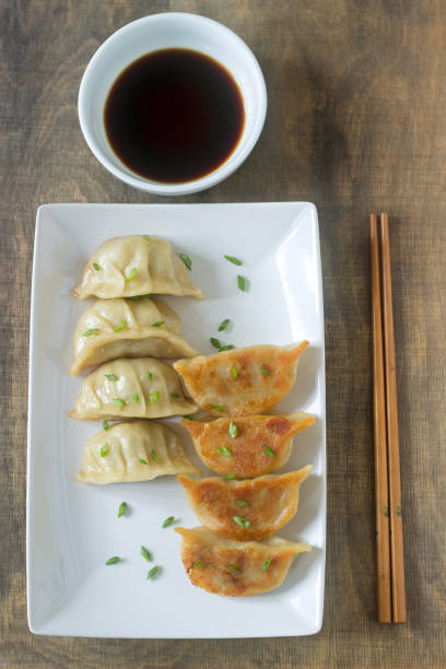 istock Eight boiled or fried jiaozi or gedza served with soy sauce. 892363006