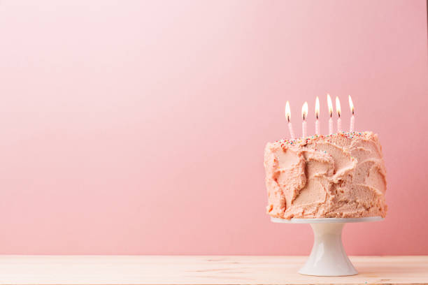 istock Pink Birthday cake with burning candles 892363032