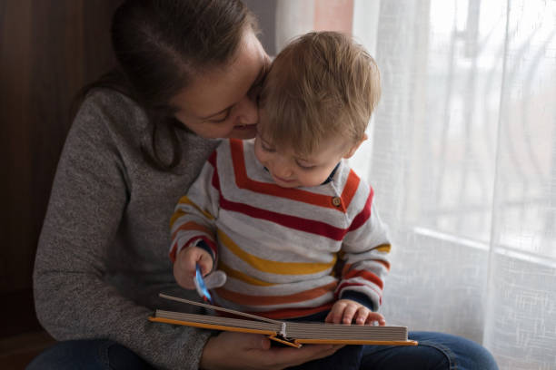 istock Mother and baby son reading a book 892363106