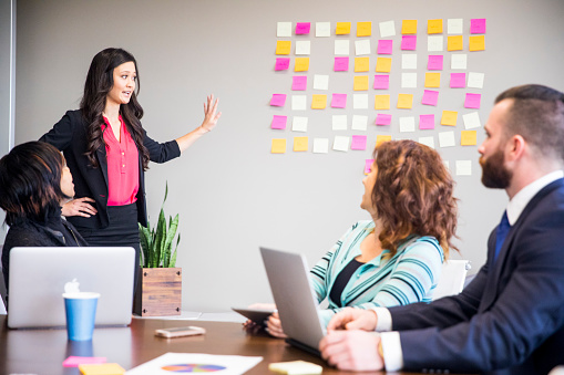 A young Asian businesswoman leads her team during a brainstorming session