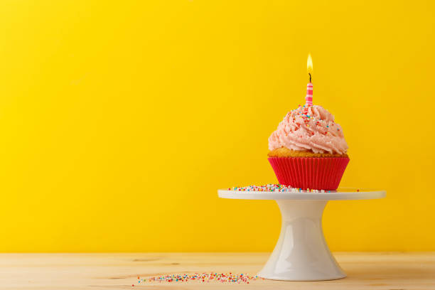 istock Decorated birthday cupcake with burning candle 892363312