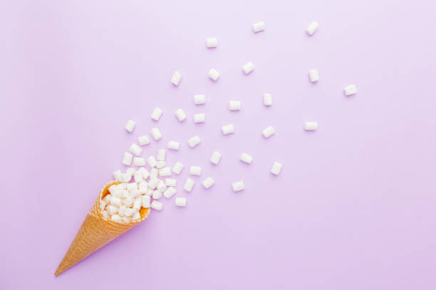 istock waffle cone and mini marshmallows on pink  background. Top view 892365910