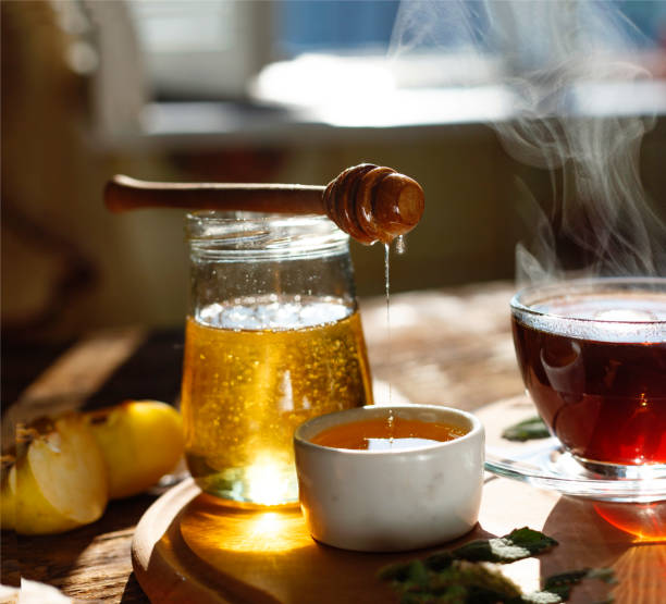 istock Natural bee honey with morning tea. Pouring honey. 892372528