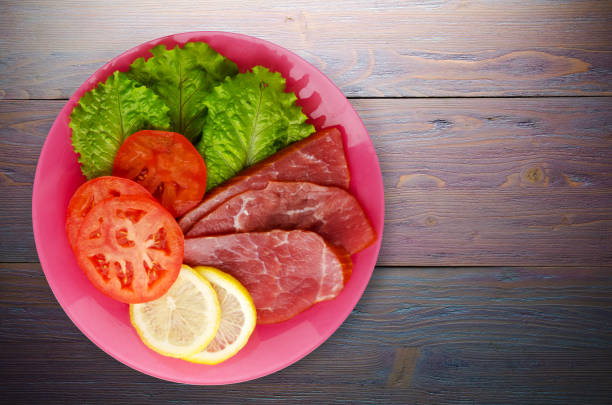 istock ham with salad, tomato and lemon on a plate. 892373032