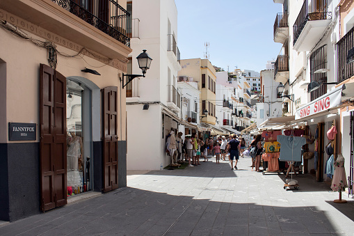 View of a shopping street with people in Ibiza. It is one of the Balearic islands, an archipelago of Spain in the Mediterranean Sea.