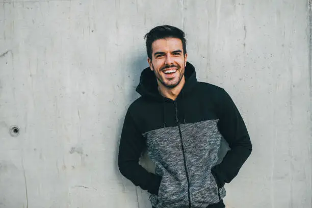 Portrait of an attractive sportsman in front of a wall.