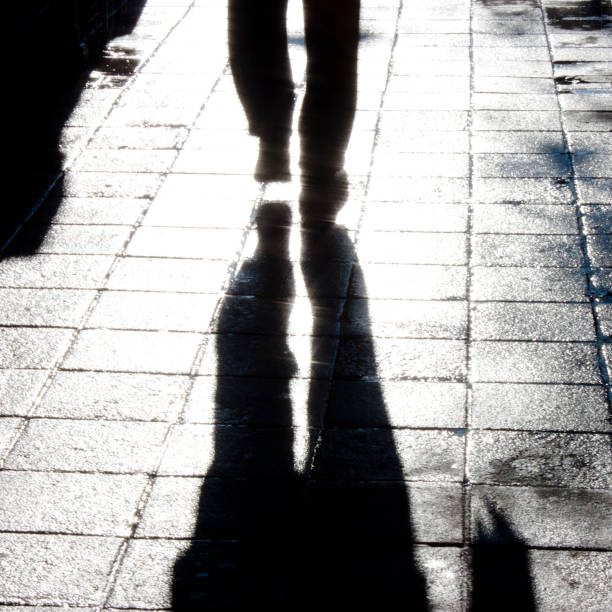 istock Blurry man legs walking city street 892382054