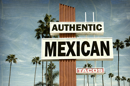 aged and worn authentic mexican food sign with palm trees