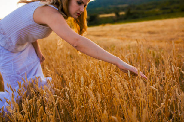 istock Young female farmer walking throw wheat field 892397810