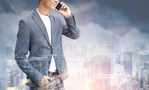 istock Unrecognizable man on phone, gray city 892403258
