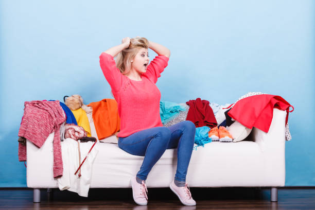 istock Woman does not know what to wear sitting on couch 892420236