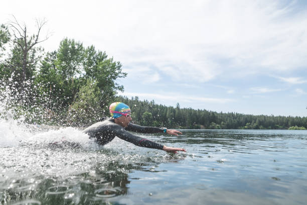 istock Female triathlon athlete diving into the water 892420276