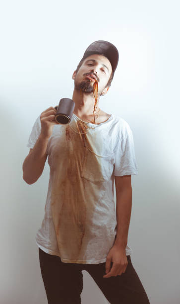istock Young men spilling coffee on t-shirt 892422554