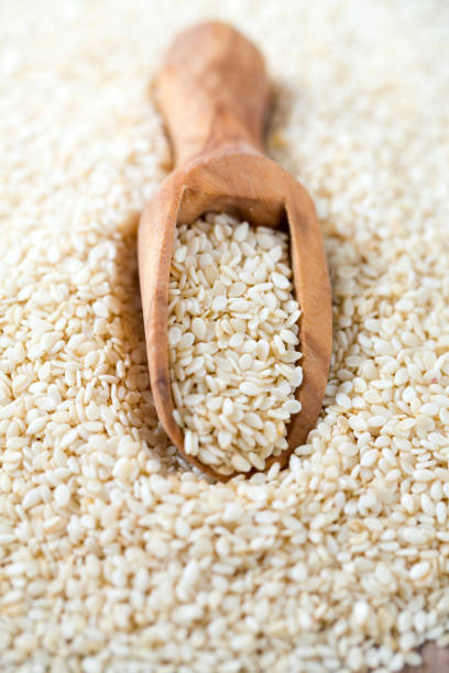 sesame seeds in a wooden scoop - sesame seed spoon scoop imagens e fotografias de stock