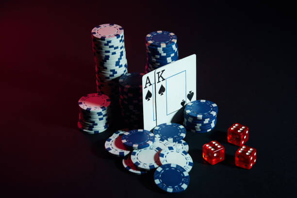 istock Stack of chips and two cards on dark background - poker game concept 892433240