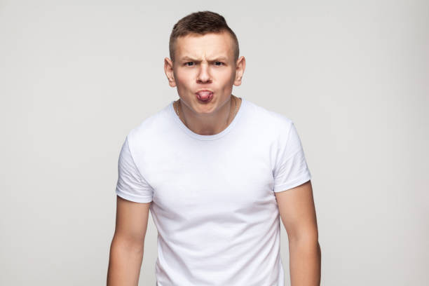 Close up tongue out. Portrait of funny young man. Close up tongue out. Portrait of funny young man. Gray background, studio shot big ears stock pictures, royalty-free photos & images
