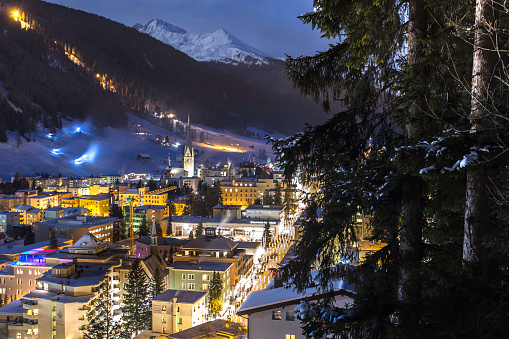 DAVOS, SWITZERLAND, CANTON GRISONS city night panorama in winter of the city and jakobshorn covered with snow. Winter ski sports resort and home of the WORLD ECONOMIC FORUM every january