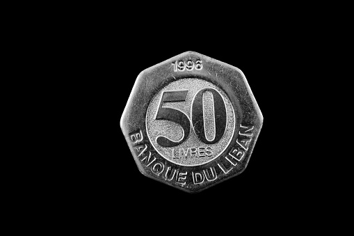 A super macro image of a Lebanese 50 livres coin isolated on a black background