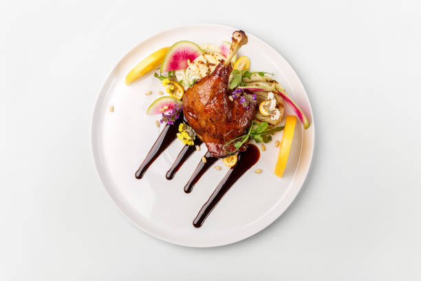 istock Chicken with vegetables on white plate served topped with berry sauce 892458202