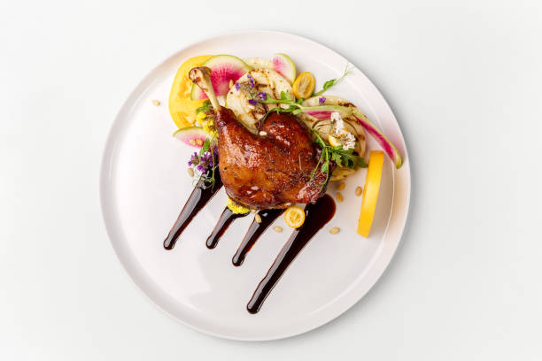 Chicken with vegetables on white plate served topped with berry sauce