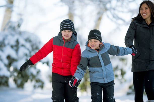 istock Mom and sons playing in snow 892460654