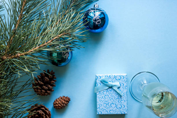 natura morta di capodanno - un bicchiere di champagne, decorazioni natalizie e rami di abete rosso su sfondo blu - wine christmas alcohol evening ball foto e immagini stock