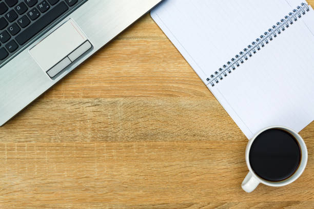istock Laptop computer or notebook, note and cup of coffee on working table with copy space top view. 892478598