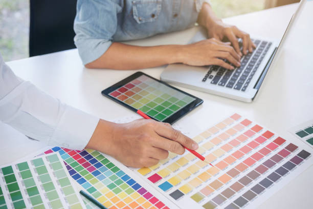 istock Young colleagues designers working together on a creative project and color samples for selection, Color swatch samples, Brainstorming Planning Partnership, creative graphic design working desktop 892507194