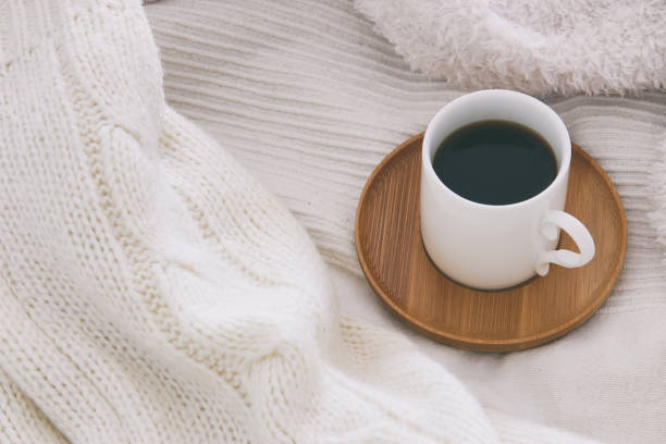 istock Cup of coffee over cozy and white blanket. Top view. 892507912