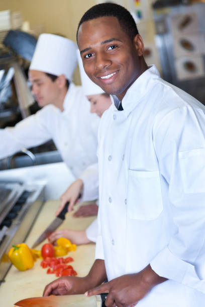 istock Young male chef chops vegetables in restaurant kitchen 892541698