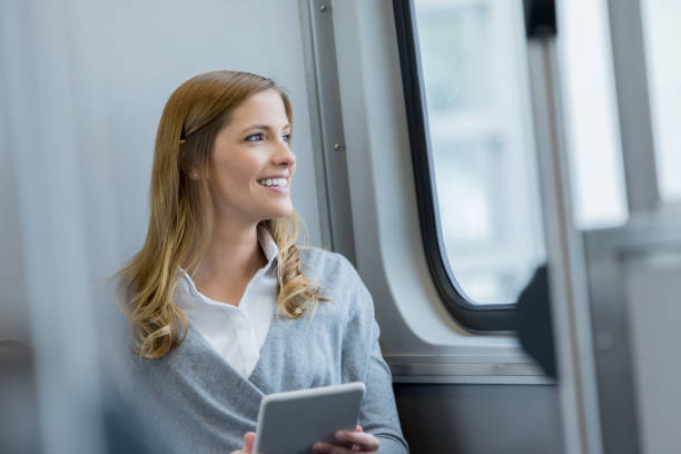 istock Woman looks out window on commuter train 892542042
