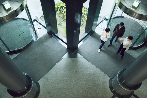 Looking down from the overhead viewpoint that members of Asian business team meet at the entrance of the office.