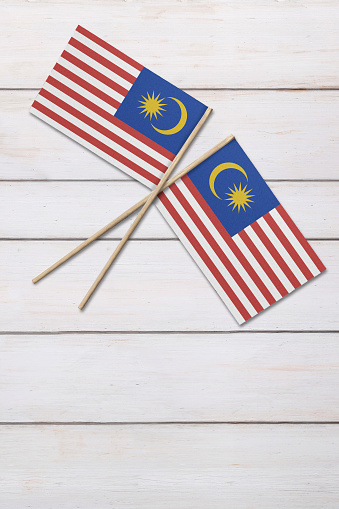 An Asian woman is holding Malaysian national flag joyfully
